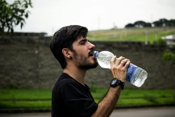 Man drinking water from a plastic water bottle